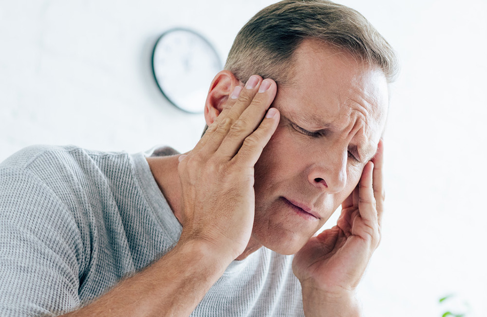 Mann mit Kopfschmerzen als möglicher Auslöser einer Epilepsie.