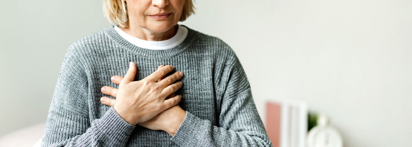 Frau mit Brustschmerzen als mögliches Symptom einer Herzklappenerkrankung