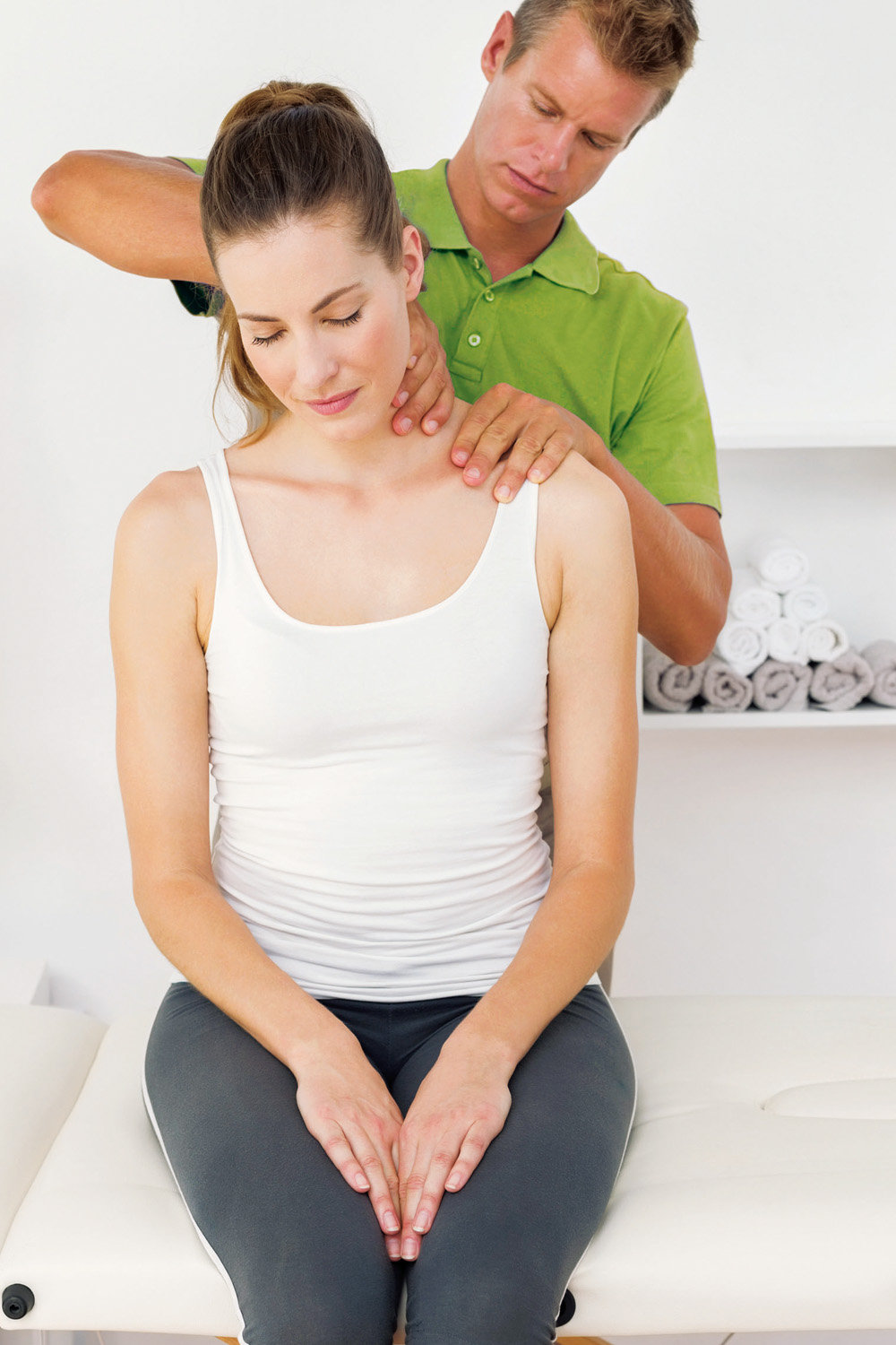 Therapeut behandelt Nacken einer Patientin als Teil eines Therapieansatzes