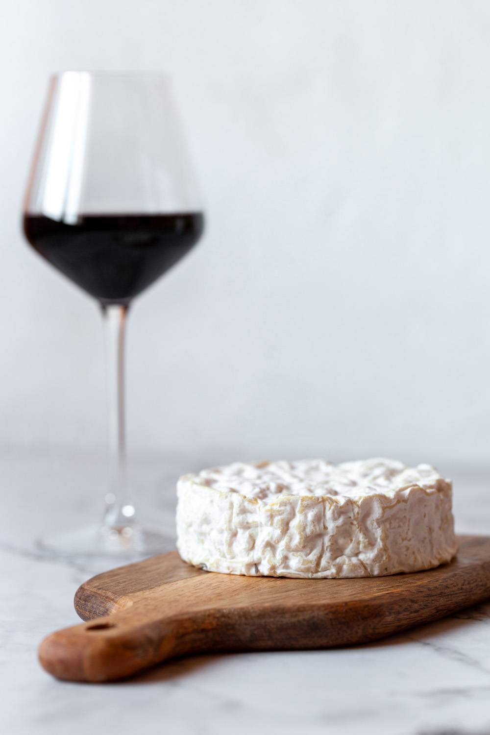 Weinglas und Käse als mögliche Auslöser für Kopfschmerzen dargestellt