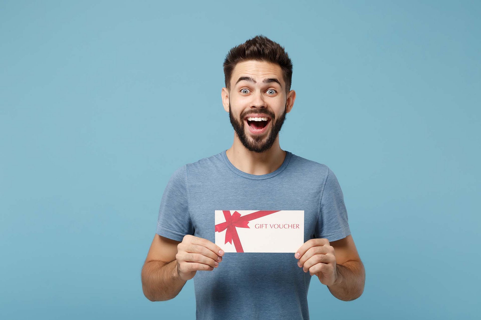 Glücklicher Mann freut sich über Geschenkgutschein von medicos.AufSchalkelle Wohlfühl-Momente verschenken.