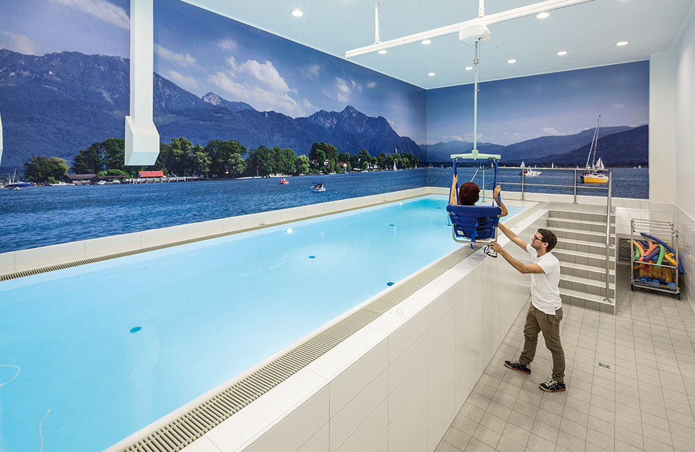 Therapeut hilft Patient beim Einstieg ins Therapiebecken